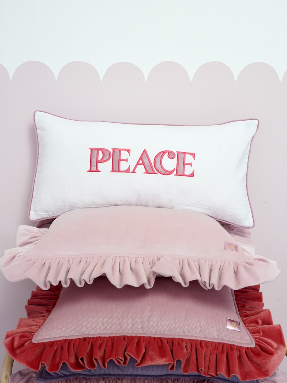 Decorative pillowcase with a pink embroidered inscription "Peace"