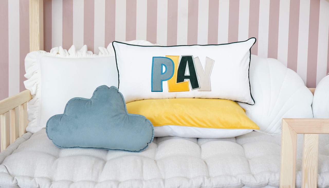 Decorative pillowcase with a colorful embroidered inscription "Play 1"