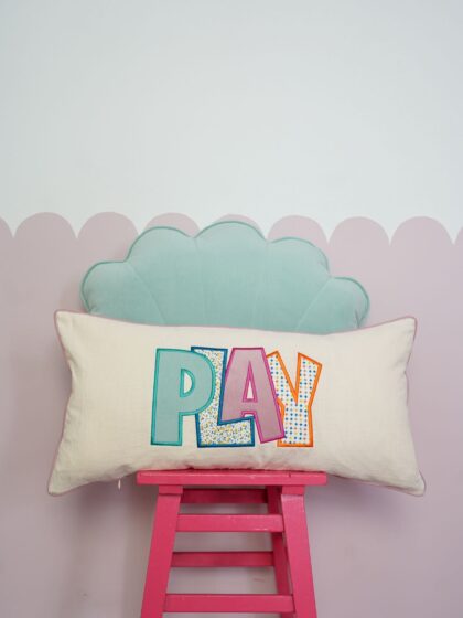 Decorative pillowcase with a colorful embroidered inscription "Play 2"